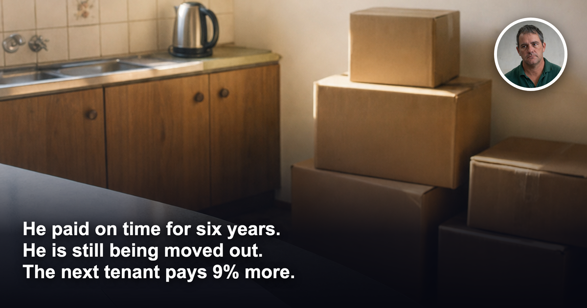 An emptied older Australian brick walk-up apartment kitchen with packed cardboard moving boxes against a bare wall and a plain printed letter and door keys on the bench